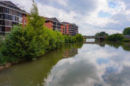 Téléchargez les photos : Bâtiments haut de gamme en brique au bord de la rivière, au bord de l'eau verdoyante et calme d'une branche de la Garonne, dans le quartier résidentiel de Saint-Michel et Tounis à Toulouse, Sud de la France - en image libre de droit