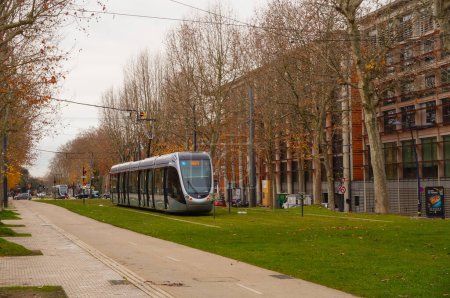 Foto de Toulouse, Francia - Abril 2019 - Un moderno tranvía de fabricación francesa situado en Allees Jules Guesde, producido por Alstom y diseñado por Airbus, en sus pistas bordeadas de árboles, frente al Palacio de Justicia - Imagen libre de derechos