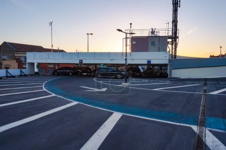 Téléchargez les photos : Toulouse, France - Juillet 2020 - Niveau supérieur du parking hors sol de Carmes au lever du soleil, avec des parkings disposés en cercle, surmonté de l'antenne relais d'une station de base installée sur le toit - en image libre de droit