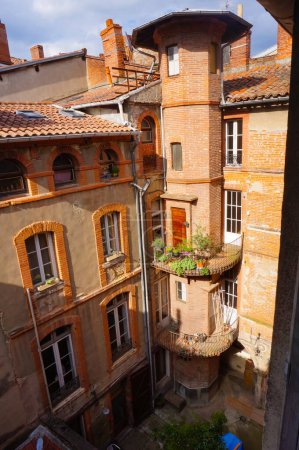 Photo for Toulouse, France - Feb. 2020 - Typical brick southern townhouses seen from the multi-storey car park in Place des Carmes, in the most expensive neighborhood of Toulouse, featuring old wooden shutters - Royalty Free Image