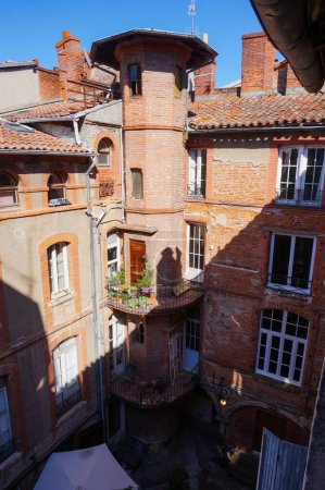 Photo for Toulouse, France - Feb. 2020 - Typical brick southern townhouses seen from the multi-storey car park in Place des Carmes, in the most expensive neighborhood of Toulouse, featuring old wooden shutters - Royalty Free Image