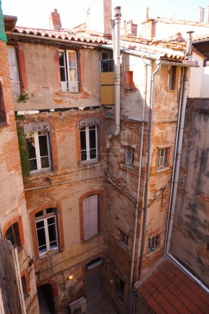 Téléchargez les photos : Toulouse, France - Feb. 2020 - Typical brick southern townhouses seen from the multi-storey car park in Place des Carmes, in the most expensive neighborhood of Toulouse, featuring old wooden shutters - en image libre de droit