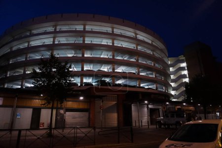 Téléchargez les photos : Toulouse, France - Sept. 2019 - Le parking à plusieurs étages de Carmes la nuit, éclairé par la lumière du néon, exploité par Indigo (Vinci Park) et construit au-dessus du marché couvert de Carmes (Carmes Market Hall) - en image libre de droit
