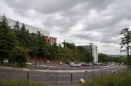 Téléchargez les photos : Toulouse, France - 21 juillet 2023 - Un parking sous la station de tramway Teleo sky, sur la pente de la colline Pech-David ; à droite, un ascenseur relie le parking au bureau d'accueil de l'hôpital Rangueil - en image libre de droit