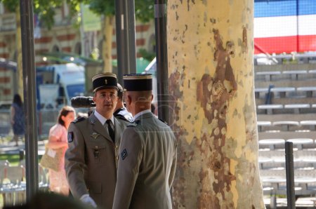 Foto de Toulouse, Francia - 14 de julio de 2023 - Preparativos para el Día Nacional en la calle antes de la ceremonia: dos teniente coroneles del Ejército francés con uniformes completos conversan frente a la galería oficial - Imagen libre de derechos
