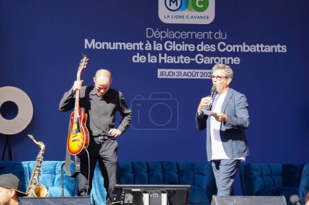 Foto de Toulouse, Francia - 31 de agosto de 2023 - Reubicación de la estructura del Franois Verdier War Memorial: un músico está en el escenario para entretener al público durante el pre-show antes del evento, tocando la guitarra - Imagen libre de derechos