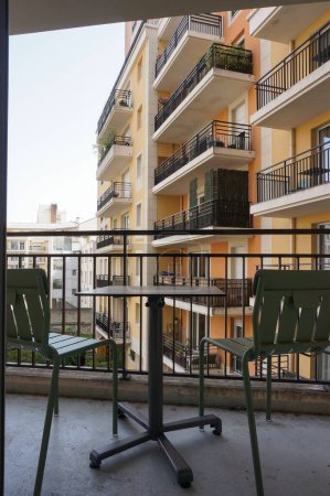 Téléchargez les photos : Montrouge, France - 5 septembre 2023 - Chaises et table sur le balcon d'une chambre de l'Aparthotel Adagio Paris Montrouge, résidence de tourisme 4 étoiles haut de gamme (Accor Hotels) près de la Porte de Chtillon - en image libre de droit