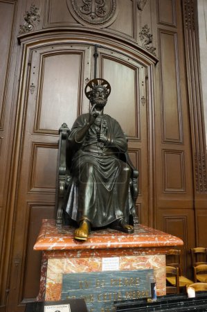 Téléchargez les photos : Paris, France - 5 septembre 2023 - Statue en bronze de saint Pierre à l'intérieur de l'église Saint-Sulpice ; le verset biblique, citation de Jésus, se référant à Pierre comme rocher (tête de l'église) est gravé sur la base - en image libre de droit