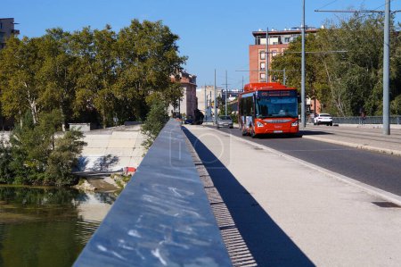 Foto de Toulouse, Francia - 7 de octubre de 2023 - Vista sobre el Pont Saint-Michel, que cruza el río Garona; el dique antiinundación es visible a la izquierda; un autobús urbano pasa por la calle apoyada por el puente - Imagen libre de derechos