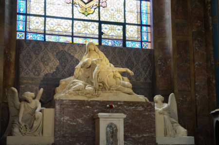 Téléchargez les photos : Paris, France - 5 septembre 2023 - Une chapelle latérale ornée d'une Pieta, sculpture en pierre représentant Marie pleurant la mort du Christ, à l'intérieur de l "église baroque Saint-Sulpice du XVIIe siècle - en image libre de droit