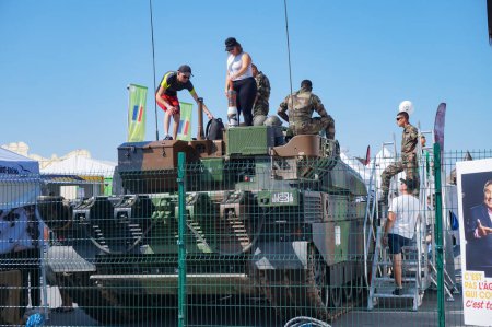 Photo for Chlons-en-Champagne - Sept. 9, 2023 -Back of a Leclerc, the French Army's Main Battle Tank (MBT), manufactured by Nexter, exhibited at Chlons Fair; visitors have climbed on the turret with soldiers - Royalty Free Image