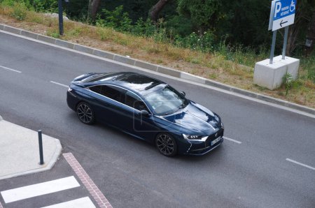 Foto de Toulouse, Francia - 21 de julio de 2023 - Vista superior borrosa por movimiento sobre un DS 9 negro, dejando un estacionamiento; el DS 9 es un automóvil ejecutivo producido en China por el fabricante francés de automóviles PSA (Stellantis).) - Imagen libre de derechos
