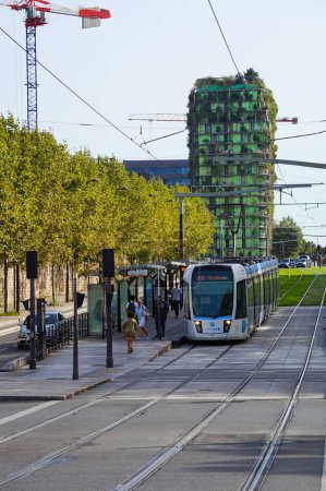 Photo for Paris, France - Sept. 6, 2023 -Tramway on RATP T3a Line, on Gnral Jean Simon Boulevard, at the platform of Avenue de France Station, in the 13th arrondissement, near the green Biodiversity Tower - Royalty Free Image