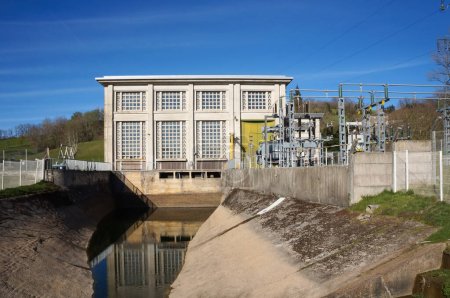 Foto de Villefranche-de-Panat, Francia - 2 de abril de 2023 - Principal de agua con muros de hormigón a la salida de una central hidroeléctrica EDF y transformador eléctrico a orillas del lago de Panat, en Lvzou - Imagen libre de derechos