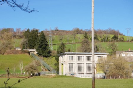 Foto de Villefranche-de-Panat, Francia - 2 de abril de 2023 - Central hidroeléctrica junto al lago de Panat: un conducto de agua impulsa el agua de aguas arriba a las turbinas, ya que cae desde la ladera de la montaña - Imagen libre de derechos