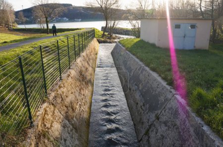 Téléchargez les photos : Villefranche-de-Panat, France - 6 avril 2023 - Une conduite d'eau pour le déversement d'une centrale hydroélectrique dans le lac de Villefranche-de-Panat, à Lvzou, une zone agricole de l'Aveyron - en image libre de droit