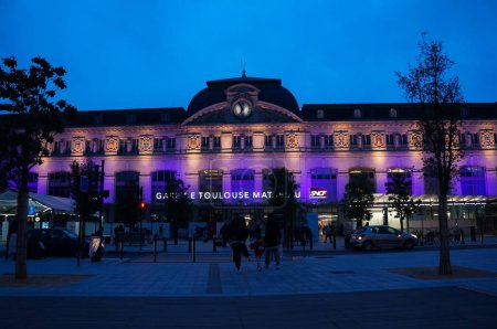 Photo for Toulouse, France - Jan. 25, 2023 - The facade of Toulouse-Matabiau Train Station is illuminated in purple at night; Matabiau is the busiest multimodal transportation hub in the Midi-Pyrnes Region - Royalty Free Image