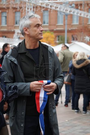 Foto de Toulouse, Francia - 12 de noviembre de 2023 - El alcalde de distrito Jonnhy Dunal sostiene la banda tricolor oficial en sus manos, en un mitin contra el antisemitismo, en medio de la guerra entre Israel y los terroristas de Hamás - Imagen libre de derechos
