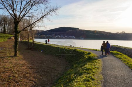Téléchargez les photos : Villefranche-de-Panat, France - 6 avril 2023 - Promenade touristique sur la promenade piétonne qui fait le tour du lac de Panat, dans la campagne de Lvzou ; tout le sentier de randonnée au bord de l'eau est à 11 km - en image libre de droit