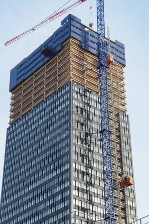 Photo for Lyon, France - Nov. 21, 2022 - Construction site of To-Lyon, the 2nd tallest skyscraper in La Part-Dieu Central Business District: the glass facade is flanked with a tower crane and freight elevators - Royalty Free Image