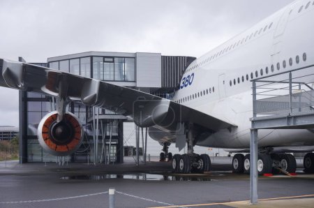 Téléchargez les photos : Toulouse, France - 21 novembre 2023 - Un Airbus A380, la plus grande plaisanterie jumbo au monde, sur le tarmac de l'aéroport Toulouse-Blagnac ; la passerelle du bâtiment d'embarquement est en place contre le fuselage - en image libre de droit