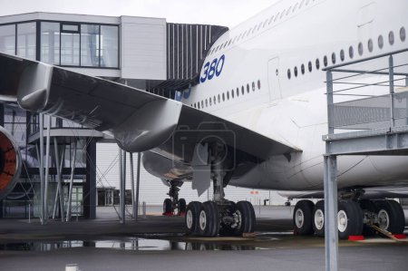 Téléchargez les photos : Toulouse, France - 21 novembre 2023 - Un Airbus A380, la plus grande plaisanterie jumbo au monde, sur le tarmac de l'aéroport Toulouse-Blagnac ; la passerelle du bâtiment d'embarquement est en place contre le fuselage - en image libre de droit