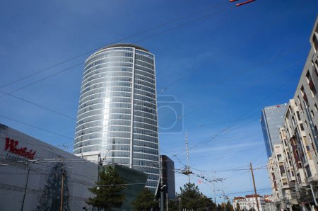 Photo for Lyon, France - Nov. 24, 2022 - Overhead lines of the tramway on Marius Vivier Merle Boulevard; Westfield Commercial Center, Oxygne Tower and Swiss Life Tower in La Part-Dieu Business District - Royalty Free Image