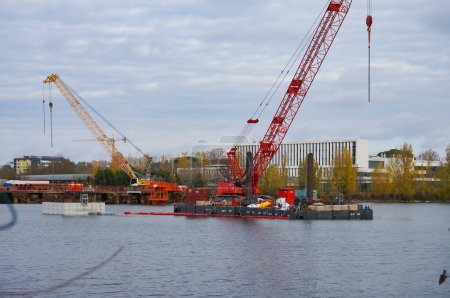 Foto de Labge, Francia - 2 de diciembre de 2023 - Grúas sobre plataformas off-shore en el sitio de construcción del viaducto para la extensión de la Línea B del metro de Toulouse, en Labge Lake, frente a INPT - Imagen libre de derechos