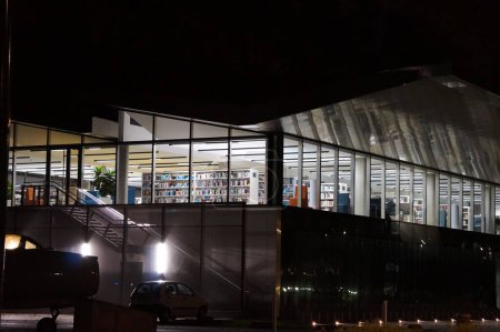 Téléchargez les photos : Toulouse, France - 7 décembre 2023 - Vue de nuit de la façade moderne en verre de l'Arothque Marie Marvingt, la nouvelle bibliothèque universitaire de l'Institut National Supérieur de l'Air et de l'Espace (ISAE-SUPAERO)) - en image libre de droit