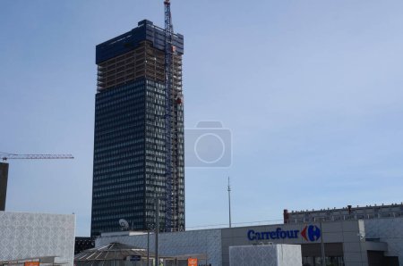 Foto de Lyon, Francia - 24 de noviembre de 2022 - En primera línea, Carrefour Hypermarket en Wesfield Commercial Center; en el fondo, To-Lyon Tower, un rascacielos en construcción en Part-Dieu Business District - Imagen libre de derechos