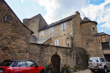 Photo for Salles-la-Source, France - Aug. 14, 2023 - Traditional stone house, composed of several bodies, likely centuries old, in the hamlet of Fontcoussergues, with a car parked at the foot of the edifice - Royalty Free Image