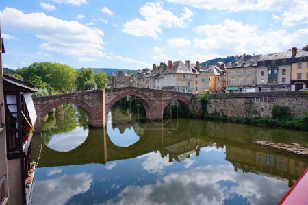Foto de Espalion, Francia - 9 de agosto de 2023 - Casas tradicionales y antiguo puente sobre el río Lot en Espalion, una ciudad ubicada en la histórica provincia de Rouergue, ahora Departamento de Aveyron en el sur de Francia - Imagen libre de derechos