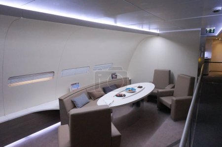 Téléchargez les photos : Toulouse, France - 21 novembre 2023 - Salon avec canapés confortables et table ovale moderne dans la cabine d'un Airbus A380 jumbo jet, exposé au musée aéronautique Aeroscopia à Beauzelle - en image libre de droit