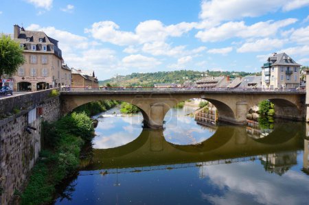 Téléchargez les photos : Espalion, France - 9 août 2023 - Maisons traditionnelles et pont en arc sur la rivière Lot à Espalion, une ville située dans la province historique de Rouergue, aujourd'hui département de l'Aveyron dans le sud de la France - en image libre de droit