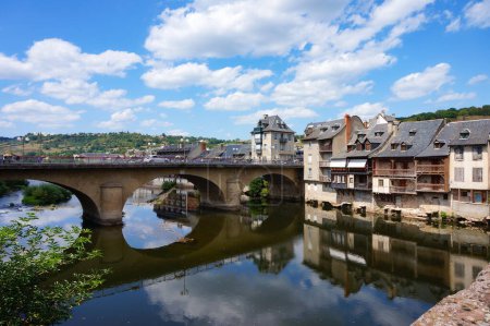 Foto de Espalion, Francia - 9 de agosto de 2023 - Antiguas curtidurías junto al río Lot y el Puente Viejo arqueado ("Pont-Vieux") en Espalion, una ciudad medieval en Rouergue, Departamento de Aveyron, en el sur de Francia - Imagen libre de derechos