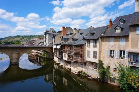 Foto de Espalion, Francia - 9 de agosto de 2023 - Antiguas curtidurías junto al río Lot y el Puente Viejo arqueado ("Pont-Vieux") en Espalion, una ciudad medieval en Rouergue, Departamento de Aveyron, en el sur de Francia - Imagen libre de derechos