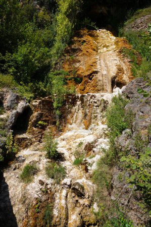 Foto de Salles-la-Source, Francia - 9 de agosto de 2023 - Caída de agua seca de La Roque ("Cascade de La Roque"): cada año, en verano, el flujo de agua se convierte en desperdicio, descubriendo las rocas cubiertas de musgo en el acantilado - Imagen libre de derechos