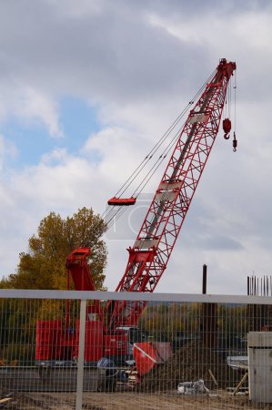 Téléchargez les photos : Labge, France - 2 décembre 2023 - Bôme métallique rouge d'une grue sur chenilles sur le chantier de Labge Viaduct, dans le parc d'affaires Palays, pour le prolongement de la ligne B du réseau de métro toulousain - en image libre de droit