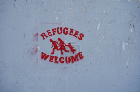 Téléchargez les photos : Toulouse, France - 15 mars 2024 - Étiquette rouge indiquant "Bienvenue aux réfugiés" sur un mur de l'Université Toulouse III-Paul Sabatier, par 3R3, un bâtiment accroupi par des milices d'extrême gauche et des immigrants irréguliers - en image libre de droit