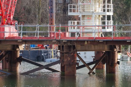 Téléchargez les photos : Labge, France - 18 février 2024 - Structures offshore temporaires sur le chantier du prolongement de la ligne B du métro toulousain : un pont en acier est construit dans l'eau, dans le lac INPT-ENSIACET - en image libre de droit