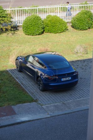 Foto de Toulouse, Francia - 5 de marzo de 2023 - Un Tesla negro (Modelo 3 o Modelo S) a la sombra en un estacionamiento; Tesla es un fabricante de automóviles estadounidense que produce automóviles totalmente eléctricos, en su mayoría sedanes. - Imagen libre de derechos