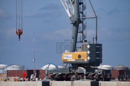 Foto de Port-la-Nouvelle, Francia - 5 de abril de 2024 - Liebherr grúa naval móvil alemana en la orilla del mar Mediterráneo, en medio de obras de desarrollo para la extensión en aguas profundas del puerto comercial - Imagen libre de derechos