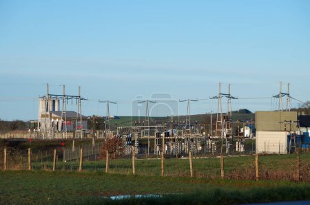 Foto de Requista, Francia - 17 de marzo de 2024 - Un transformador eléctrico para recoger la energía producida por los aerogeneradores en colinas cercanas, conectadas a través de líneas de alta tensión, en una zona rural de Aveyron - Imagen libre de derechos