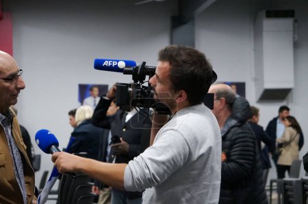 Foto de Toulouse, Francia - 26 de abril de 2024 - Un periodista de AFP, la Agencia de Prensa Francesa, equipada con una cámara de televisión y un micrófono, entrevista a un miembro del partido Les Republicans después de un mitin electoral - Imagen libre de derechos