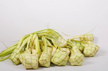 Photo for Ketupat (rice dumpling on white background) for background. Ketupat is a natural rice casing made from young coconut leaves for cooking rice during eid Mubarak. Copy space for text card design, isolated white background - Royalty Free Image