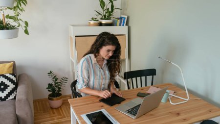 Téléchargez les photos : Photo ci-dessus d'une femme d'affaires heureuse travaillant à la maison sur un ordinateur portable et un bloc-notes - en image libre de droit