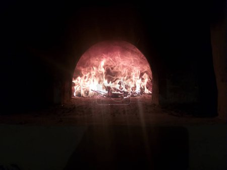 a bright hot fire burning in the oven in the dark