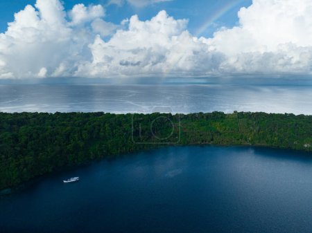 Téléchargez les photos : Un faible arc-en-ciel apparaît derrière une île tropicale reculée des îles Salomon. Ce beau pays abrite une biodiversité marine spectaculaire et de nombreux sites historiques de la Seconde Guerre mondiale. - en image libre de droit