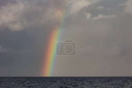 Téléchargez les photos : A bright rainbow appears over the South Pacific Ocean during the monsoon season. - en image libre de droit