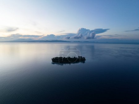 Téléchargez les photos : Dawn illumine une île isolée de Raja Ampat, en Indonésie. Ces régions tropicales reculées soutiennent un éventail incroyable de biodiversité. - en image libre de droit
